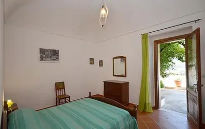 a bedroom with a bed and a sliding glass door at B&B Raggio Verde in Castelluzzo