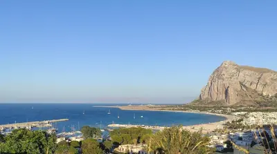 a view of a beach with a mountain and the ocean at Katia Home - San Vito lo Capo in San Vito lo Capo