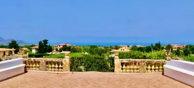 a backyard with a fence and a view of the ocean at History and Art Casa Bellacera in Casteldaccia