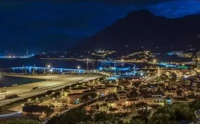 a city at night with a beach and a mountain at Casa Ponticello in Termini Imerese
