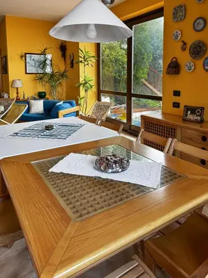 a dining room with a wooden table and yellow walls at Villa Tecla in Altofonte