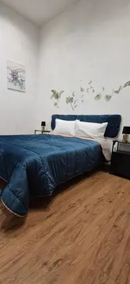 a large blue bed in a room with a wooden floor at La Casuzza 2 in piazzetta in Palermo