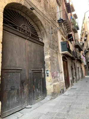 an old building with a large wooden door on a street at Vucciria Holiday - Centro storico - via Emanuele in Palermo