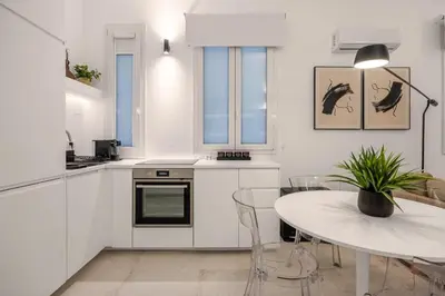 a white kitchen with a table and a dining room at Appartamento Amari 148 in Palermo