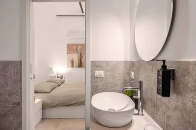 a bathroom with a tub and a bed and a mirror at Appartamento Amari 148 in Palermo