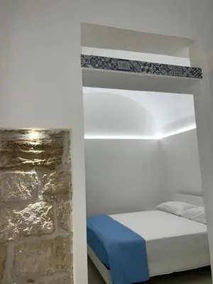 a bedroom with a bed and a stone wall at La Maiolica 61 in Terrasini
