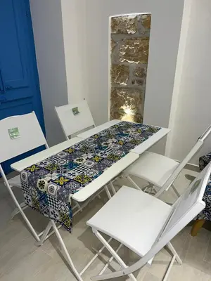 a table with two chairs and a table with a tablecloth on it at La Maiolica 61 in Terrasini