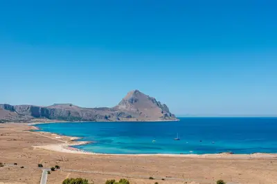 a view of a beach with a mountain in the background at Case Vacanza Loria in Castelluzzo