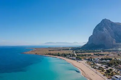 an aerial view of a beach with a mountain in the background at Case Vacanza Loria in Castelluzzo