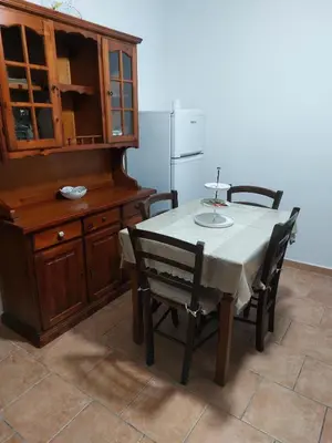 a kitchen with a table with chairs and a refrigerator at Il Rifugio Delle Giuiuzze in Palermo