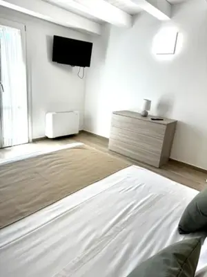 a kitchen with a table and a white refrigerator at Terrasini Center Apartments in Terrasini