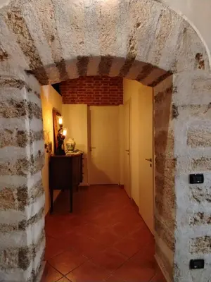 a hallway with a brick wall and a door at Vittorio Cathedral House in Palermo