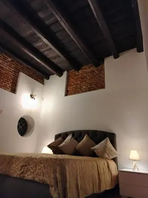 a bedroom with a bed and a brick wall at Vittorio Cathedral House in Palermo