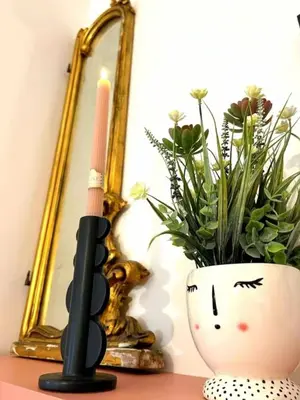 a candle and a vase on a table with a plant at Casamori 1-centro storico Palermo in Palermo