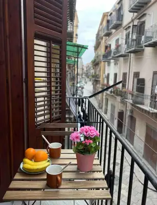 a table with fruit and flowers on a balcony at Casamori 1-centro storico Palermo in Palermo