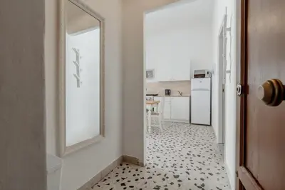 a hallway with a mirror and a kitchen at GuestHost - La Rosa di Ballarò Palermo Apartment in Palermo