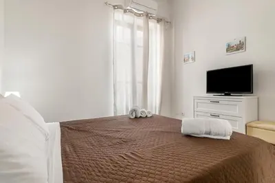 a bedroom with a bed with a flat screen tv at GuestHost - La Rosa di Ballarò Palermo Apartment in Palermo