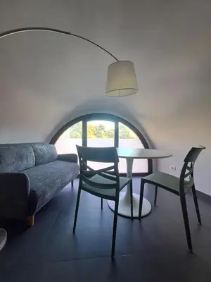 a living room with a table and chairs and a couch at La Lunetta - romantic little house in Palermo