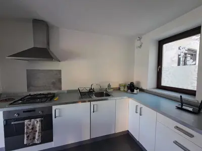 a kitchen with white cabinets and a sink and a window at La Lunetta - romantic little house in Palermo
