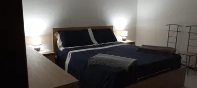 a bedroom with a bed with blue sheets and two lamps at Molo Sbrijù - Palermo Centro in Palermo