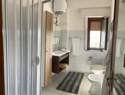 a white bathroom with a toilet and a sink at Molo Sbrijù - Palermo Centro in Palermo
