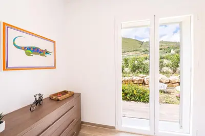 a room with a dinosaur picture on the wall next to a door at Villa Manù country house in Castellammare del Golfo