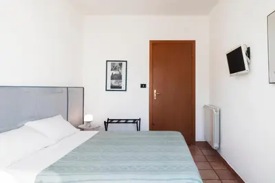 a bedroom with a bed and a door with a television at Cathedral View Apartment 2 Stanze Matrimoniali con Balcone in Centro in Palermo
