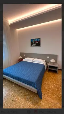 a bedroom with a large bed with a blue blanket at Clar Suite -Grattacielo in Palermo