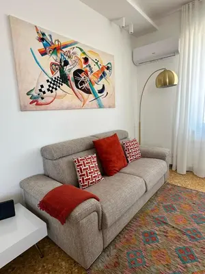 a living room with a couch and a painting on the wall at Clar Suite -Grattacielo in Palermo