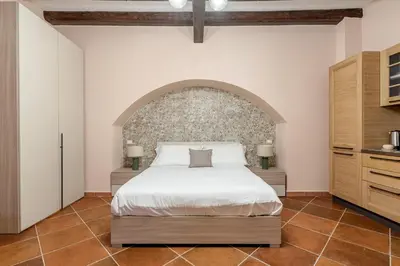 a bedroom with a bed and a brick wall at Alabardieri Apartments by Wonderful Italy in Palermo