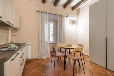 a kitchen and dining room with a table and chairs at Alabardieri Apartments by Wonderful Italy in Palermo