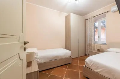 a bedroom with two beds and a window at Alabardieri Apartments by Wonderful Italy in Palermo