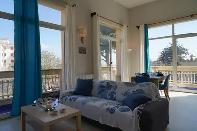 a living room with a wooden table and blue chairs at Sirene Blu Mondello in Palermo