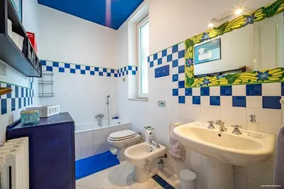 a bathroom with a toilet and a sink and a window at Sirene Blu Mondello in Palermo