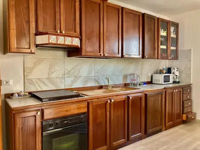 a kitchen with wooden cabinets and a sink and a stove at Villa Falco in Carini