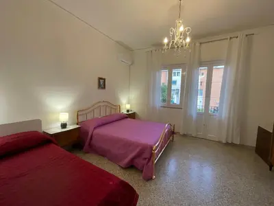 a bedroom with two beds and a chandelier at Pretty Holiday House in Palermo