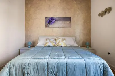 a bedroom with a blue bed with two pillows at Baglio dei Conti d'Orléans in Palermo