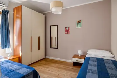 a bedroom with two beds and a mirror at Baglio dei Conti d'Orléans in Palermo