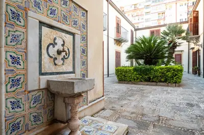 a sink on the side of a building with blue and white tiles at Baglio dei Conti d'Orléans in Palermo
