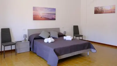 a bedroom with a large bed with two chairs at Terrasini downtown City Life in Terrasini