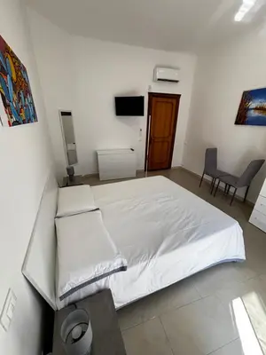 a bedroom with a large bed with white sheets at Terrasini downtown City Life in Terrasini