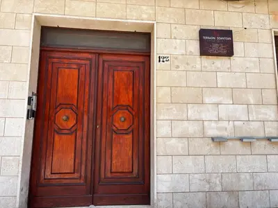 a pair of wooden doors on a brick building at Terrasini downtown City Life in Terrasini