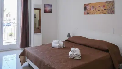 a bedroom with a bed with towels and shoes on it at Terrasini Downtown Little Square in Terrasini