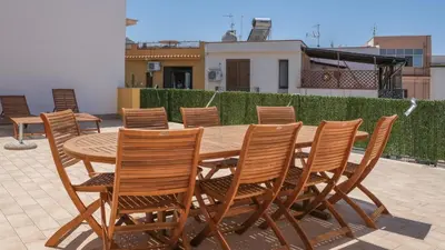 a wooden table and chairs on a patio at Terrasini Downtown Little Square in Terrasini