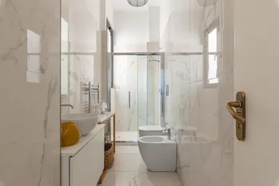 a white bathroom with two sinks and a toilet at La Casa al Foro Vista Mare by Wonderful Italy in Palermo
