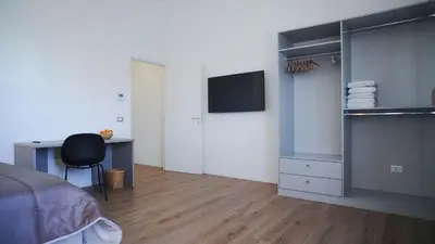 a bedroom with a bed and a desk and a tv at Harbour Front - Luxury Rooms in Palermo