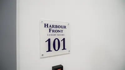 a sign hanging on a wall with the words harbour frontront inventory rooms at Harbour Front - Luxury Rooms in Palermo