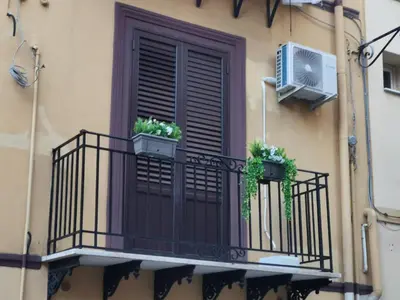 a window with two potted plants on a balcony at Primo Piano in Palermo