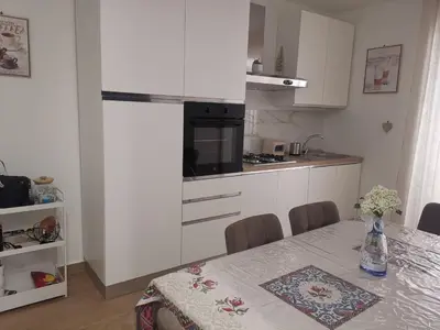 a kitchen with a dining table and a kitchen with white cabinets at Primo Piano in Palermo