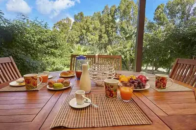 a table with food and drinks on a wooden table at Villa Rossa by Sicily Travelling Villas in Scopello